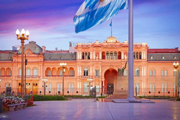 Casa Rosada al atardecer con la bandera argentina ondeando en Plaza de Mayo, símbolo institucional de Buenos Aires.