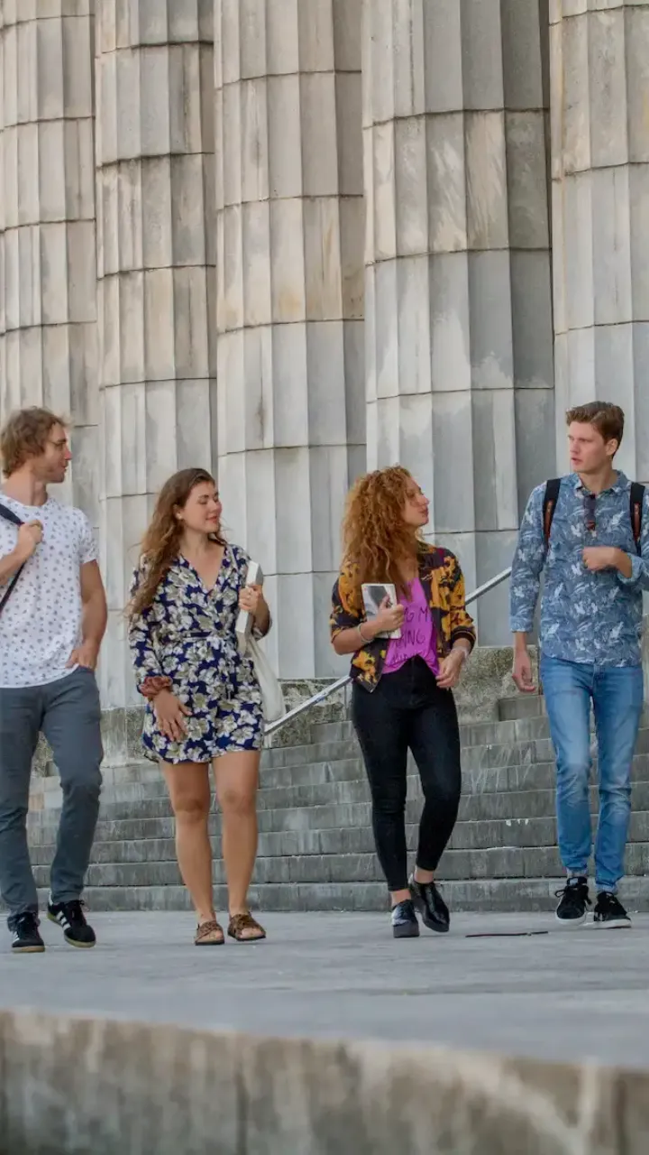 Estudiantes internacionales saliendo de la Facultad de Derecho de la Universidad de Buenos Aires, con la Floralis Genérica y la ciudad de fondo, como parte del programa académico de Consultora Puentes.